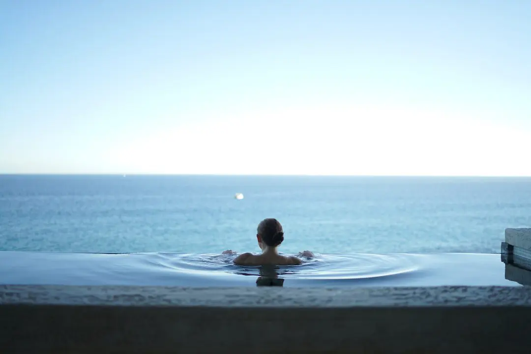 Photo by Alex Bertha Relaxed woman floating in a pool, representing stress relief for healthier skin