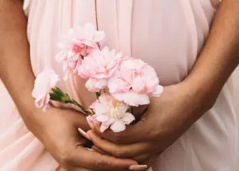 A pregnant woman holding a bouquet of flowers
