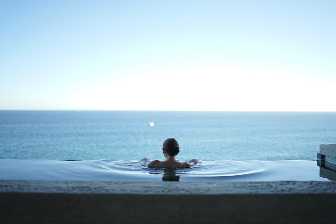 Relaxed woman floating in a pool, representing stress relief for healthier skin